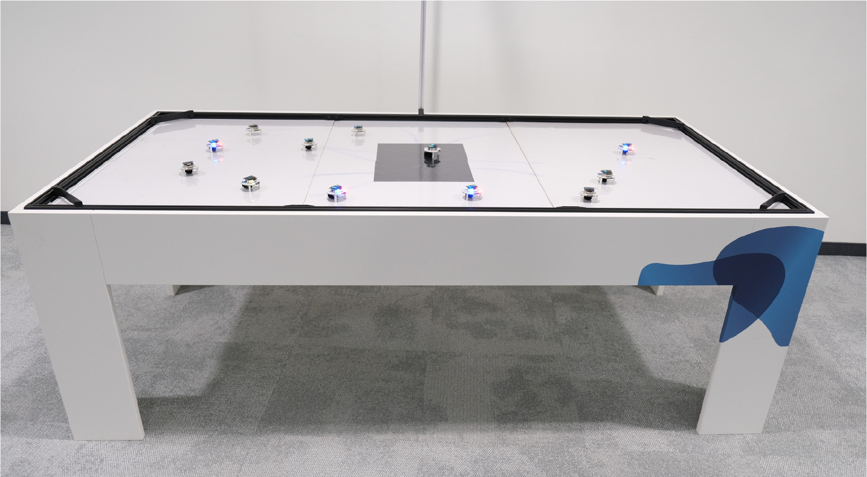 Large framed table that serves as an arena for the Dezibots