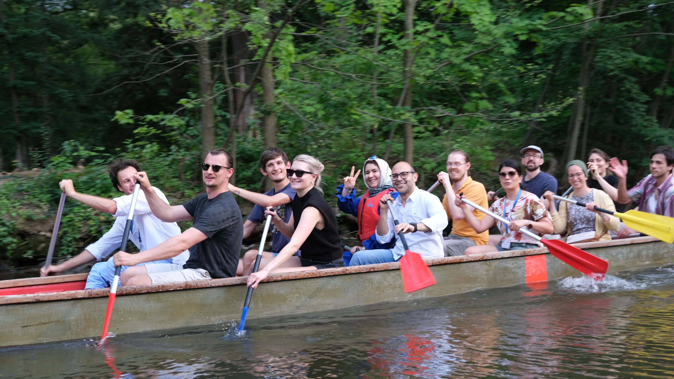 Participants rowing in a dragon boat, showcasing teamwork and collaboration at the Summer School.