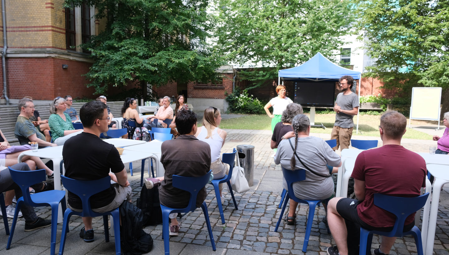 Photo. Participants listening to the introduction at KI Frühstück 2023.