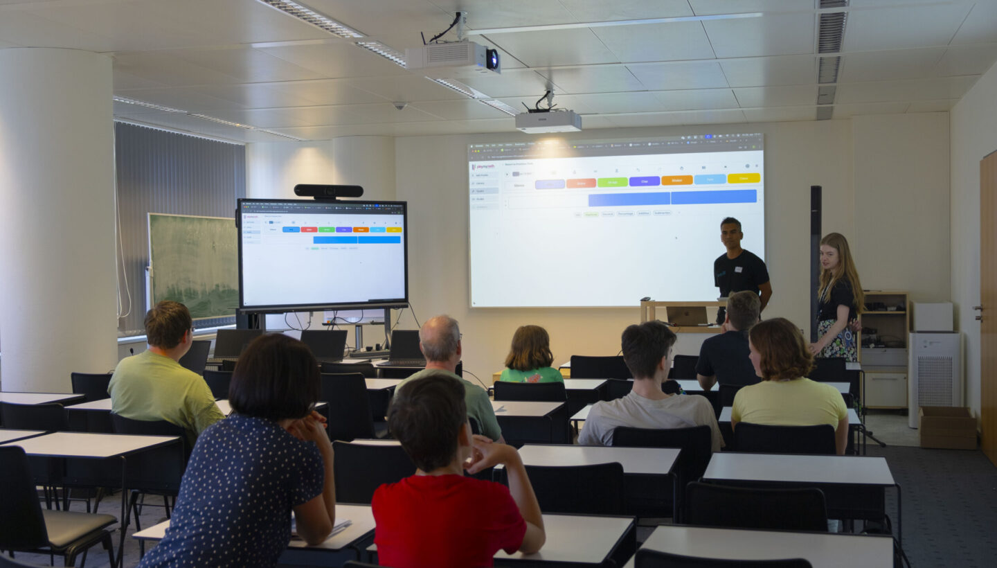 Photo. Eric Roldan and his assistant run the “Play my Math” workshop with interested visitors.
