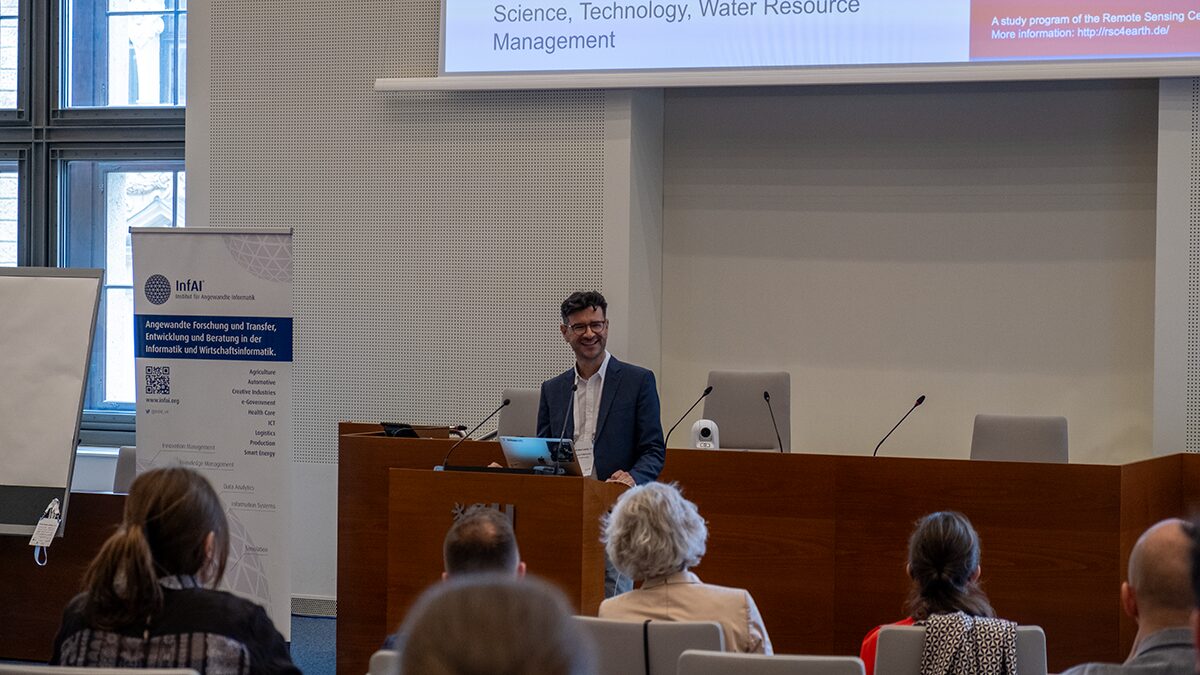Photo. Prof. Miguel Mahecha in front of the Data Week 2025 audience, giving his keynote talk.