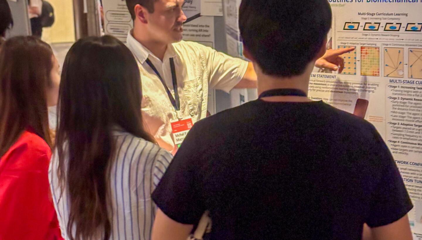 Photo. Michal Miazga presents his poster about RL-Driven Biomechanical Models in HCI.