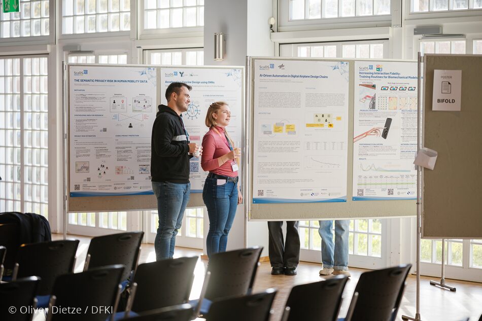 Photo. Michal Miazga and Miriam Louise Carnot are having a look at the posters of ScaDS.AI Dresden/Leipzig before the offical opening of the All Hands Meeting 2025. © Oliver Dietze / DFKI