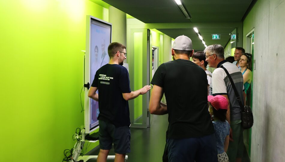 Photo. Eike Kühn is guiding a large audience to the process of using the Magic Mirror Demo and Lange Nacht der Wissenschaften Dresden 2026.
