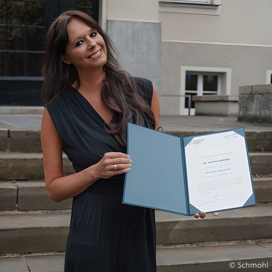 Photo. Dr. Sandra Hummel is proudly holding her TUD Young Investigator certificate. © Schmohl