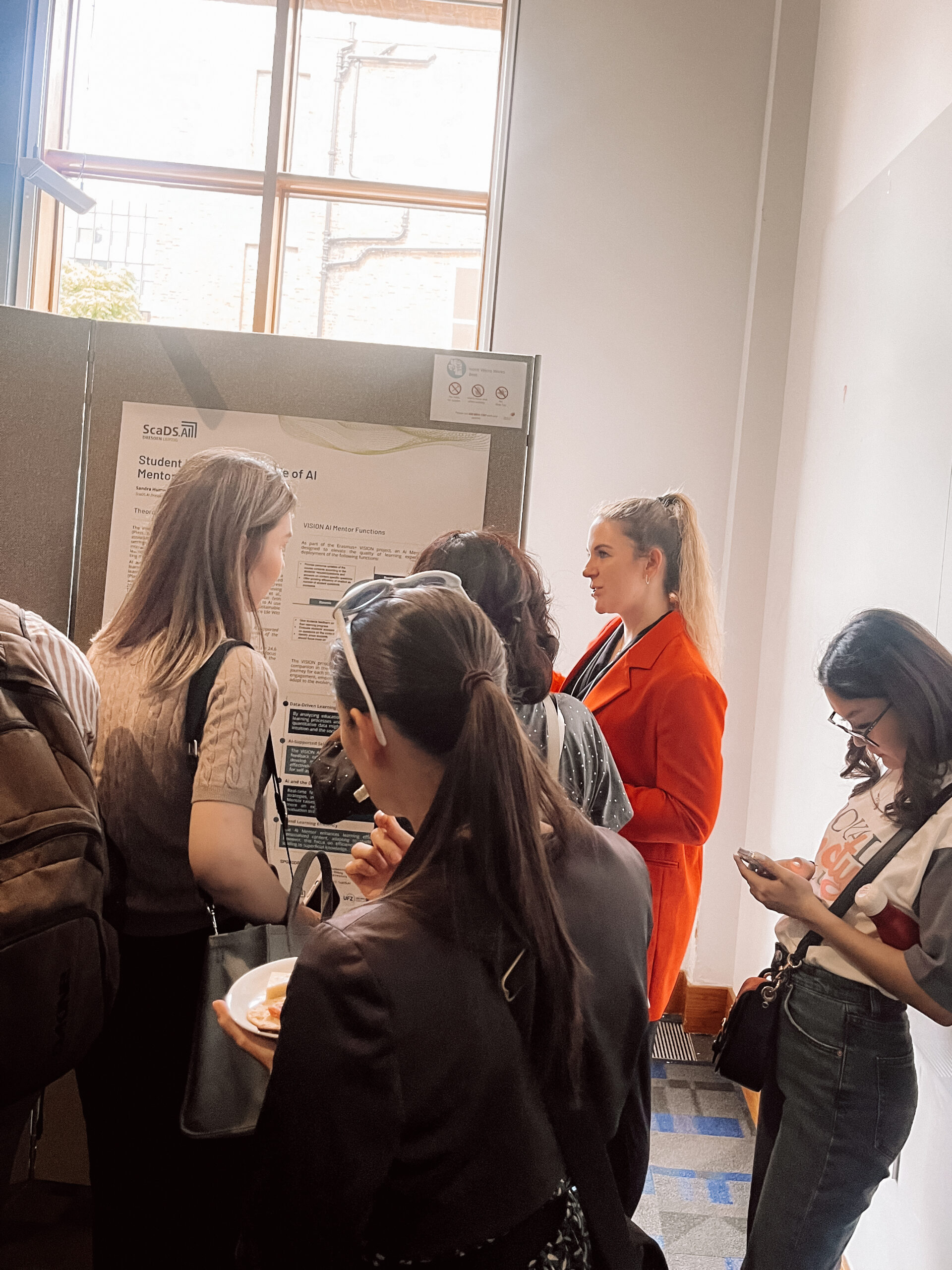 Photo. Mana-Teresa Donner presenting the group's poster at the poster session.