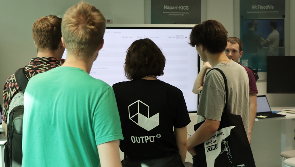 Photo. Simon Razniewski is presenting GPTKB at a monitor at a Living Lab to the visitors of OUTPUT.DD 2025.