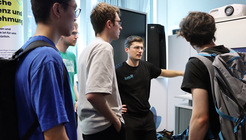 Photo. Elias Werner is explaining his demonstrator "JUmPER: Jupyter meets Performance" to visitors at the Living Lab.