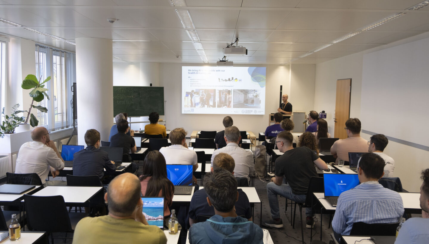 Photo. Oliver Welz presents the Living Lab while the room is full of interested people.