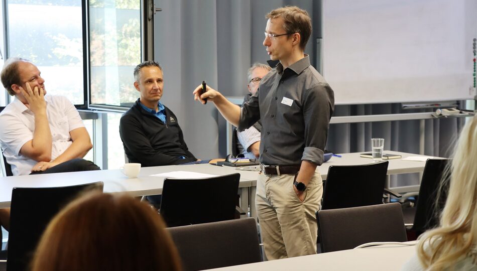 Photo. Dr. René Jäkel is introducing our guests from the Saxon State Ministry of Finance to ScaDS.AI Dresden/Leipzig, CIDS, and the AI ecosystem in Germany.