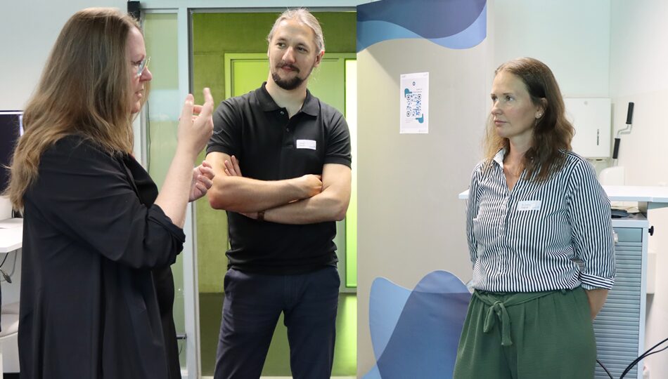 Photo. Dr. Iryna Okhrin talking to two visitors at the Living Lab.