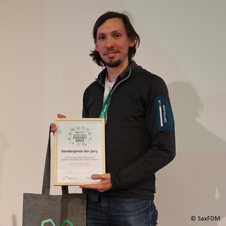 Photo. Dr. Markus Wolfien is holding the SaxFDM Open Data Award in his hands. © SaxFDM