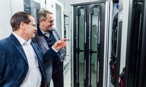 Photo. Professor Jens Meiler (right) and Professor Christian Mayr inspect the new AI chip-controlled system at Leipzig University. Photo: Christian Hüller, Leipzig University