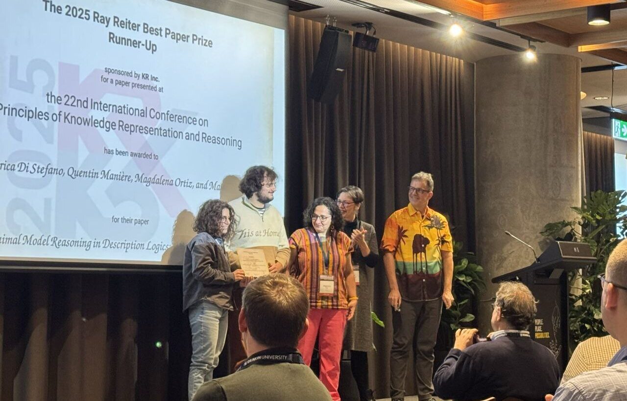 Photo. Federica Di Stefano, Quentin Mainière and Magdalena Ortiz accepted the Best Paper Award Runner-Up, presented by  Renata Wassermann and Torsten Schraub.